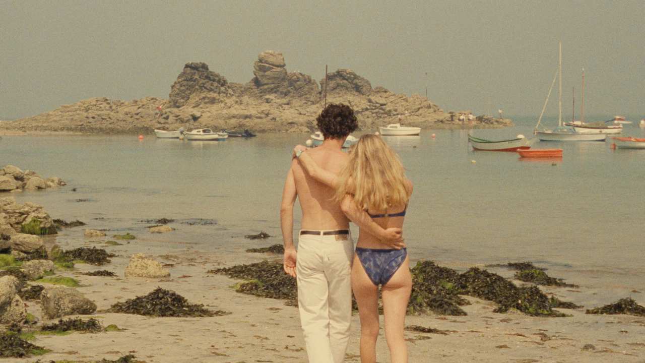 a man and woman walking together on the beach
